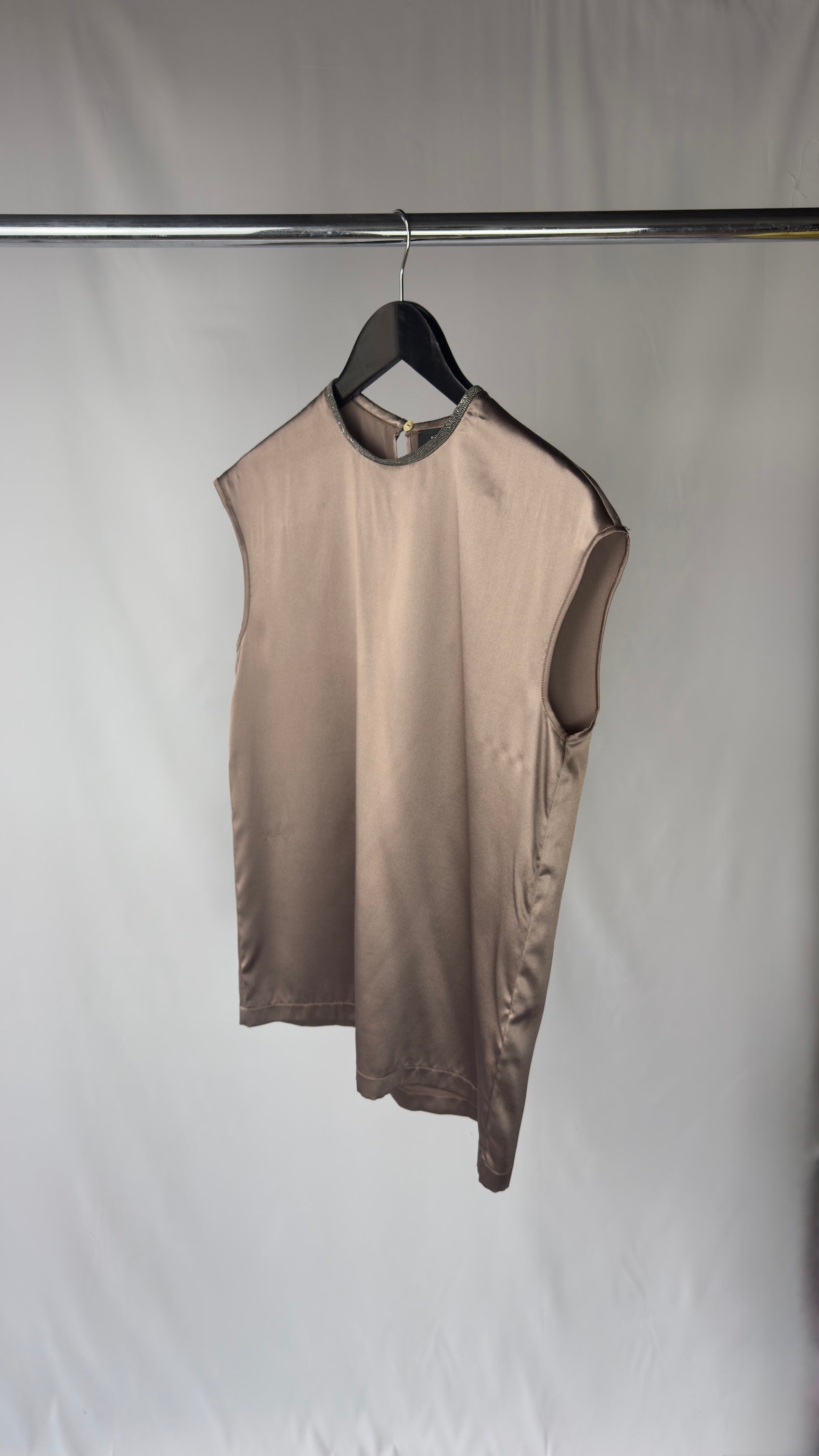 chocolate sleeveless top on a hanger against a plain background