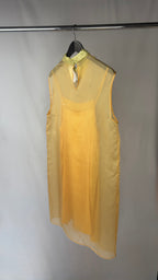 Yellow dress on a hanger against a white background