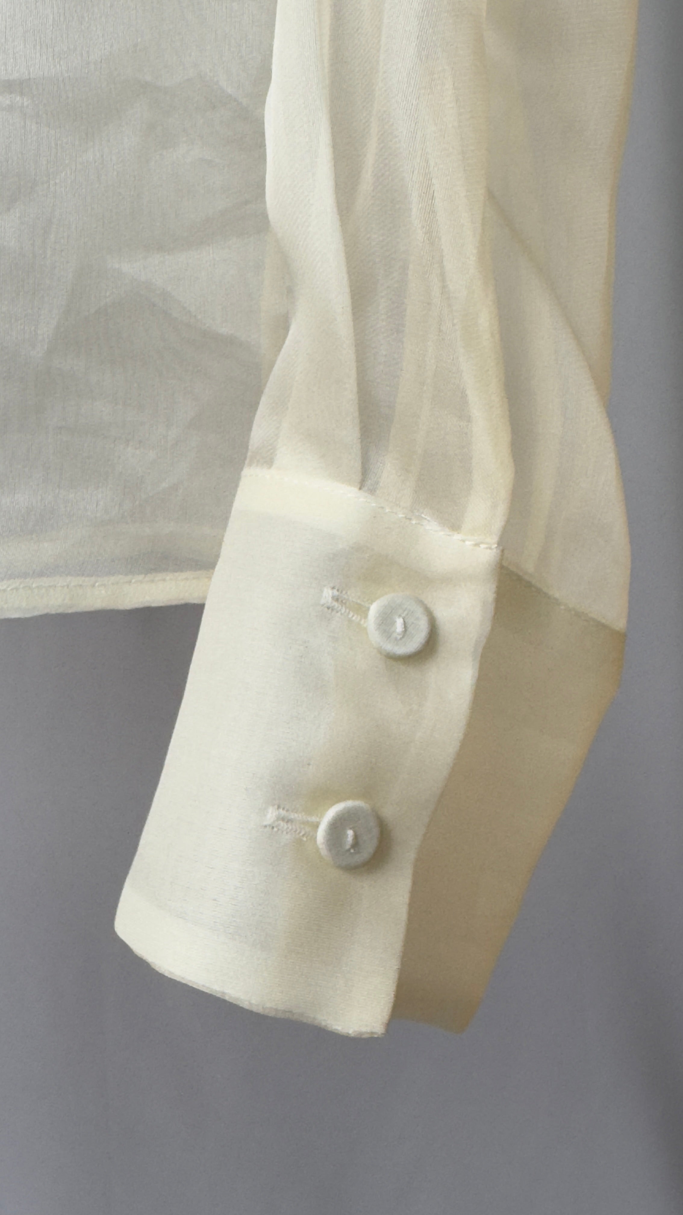 Close-up of a white shirt with buttons on a gray background