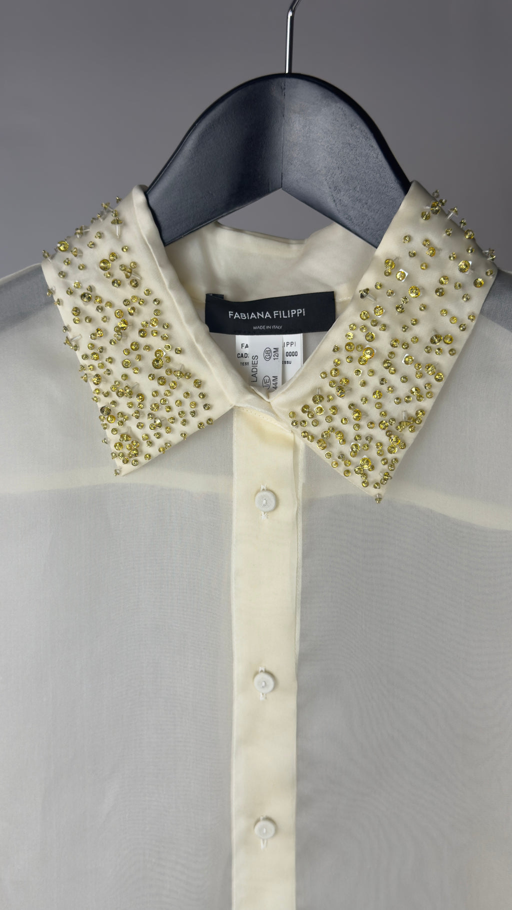White shirt with embellished collar on a hanger, brand label visible