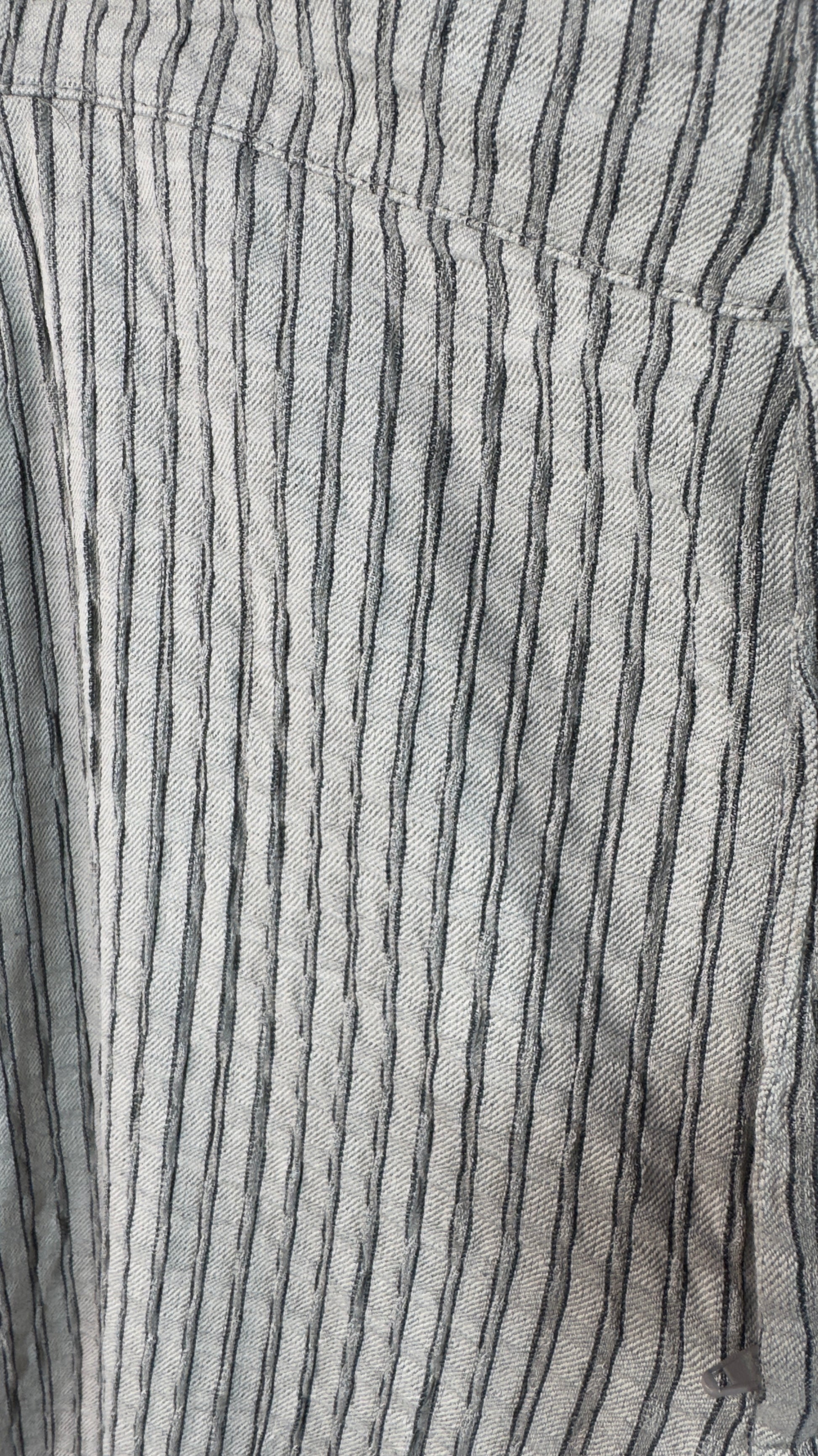 Close-up of a fabric with black vertical stripes on a gray background