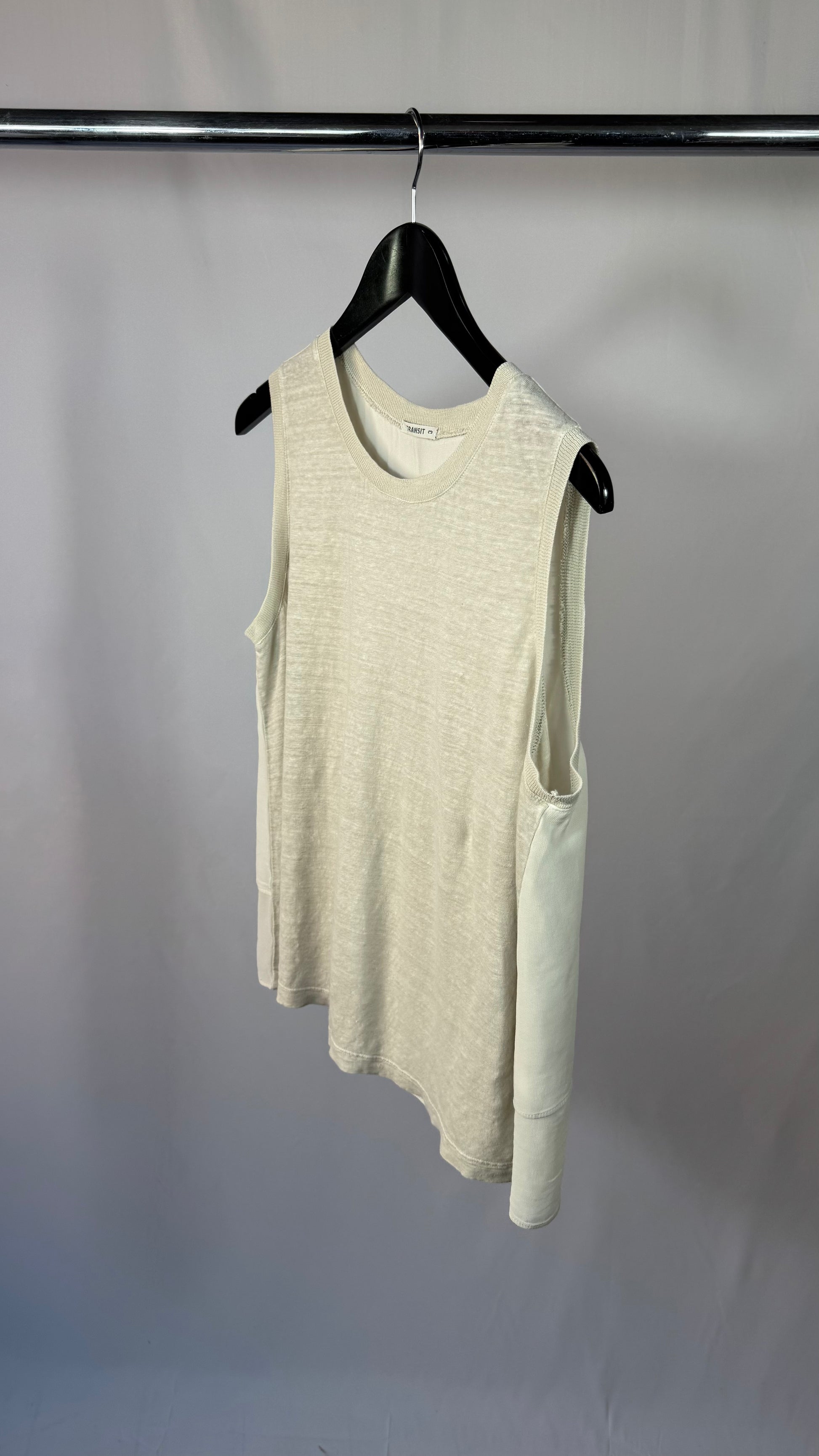 Beige sleeveless dress on a hanger against a plain background