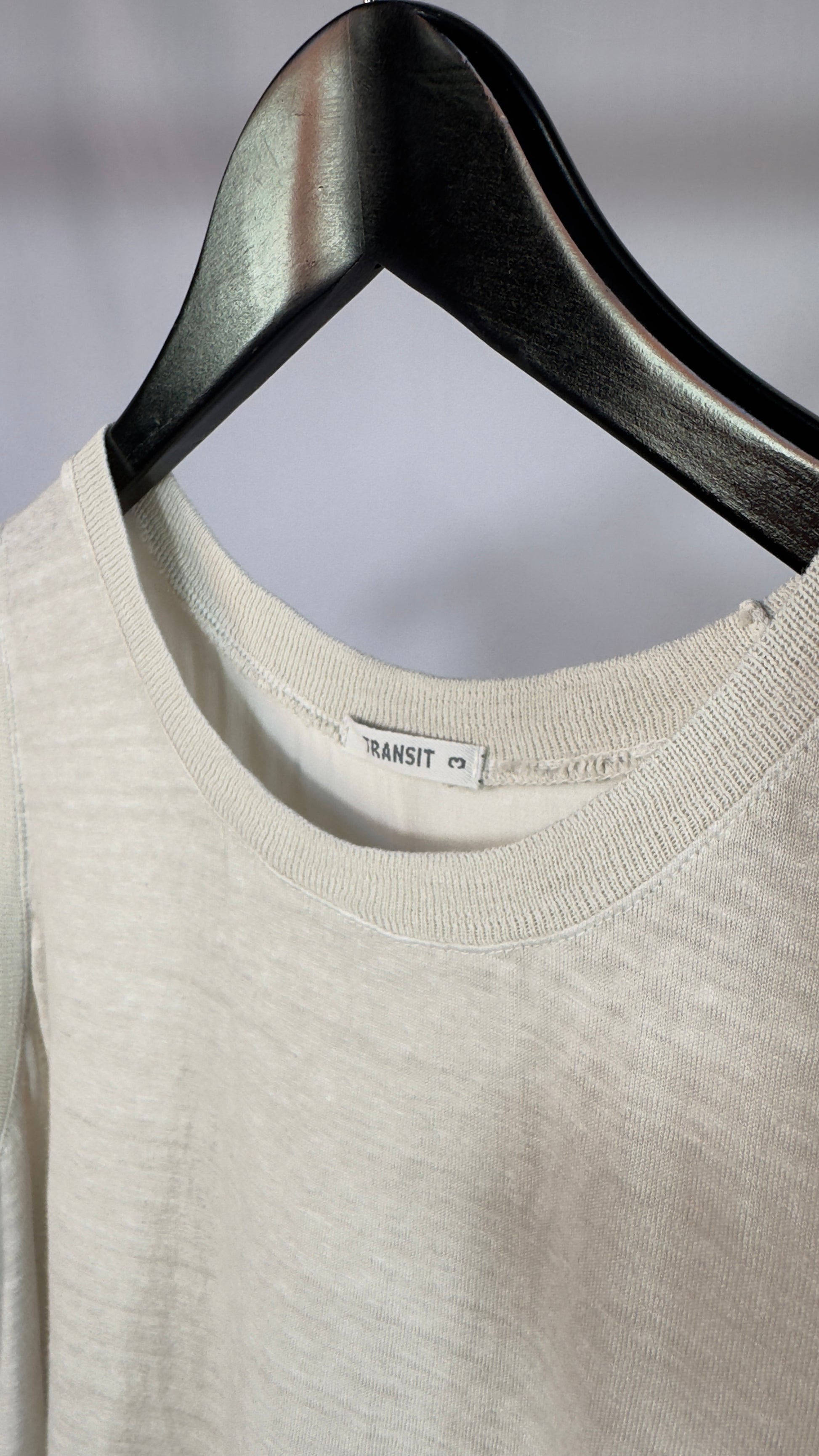 Beige sweater on a hanger with a blurred background