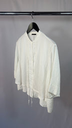 White shirt on a hanger against a plain background