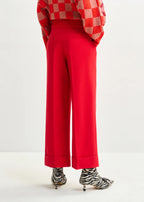 Person wearing red checkered sweater and red pants with zebra-striped shoes on a white background