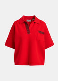 Red polo shirt with decorative trim on a white background