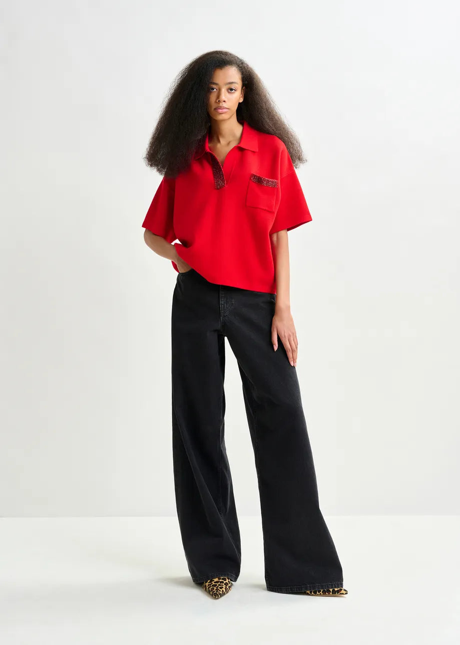 Woman wearing a red shirt and black pants on a white background