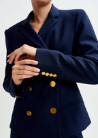 Navy blue blazer with gold buttons on a white background