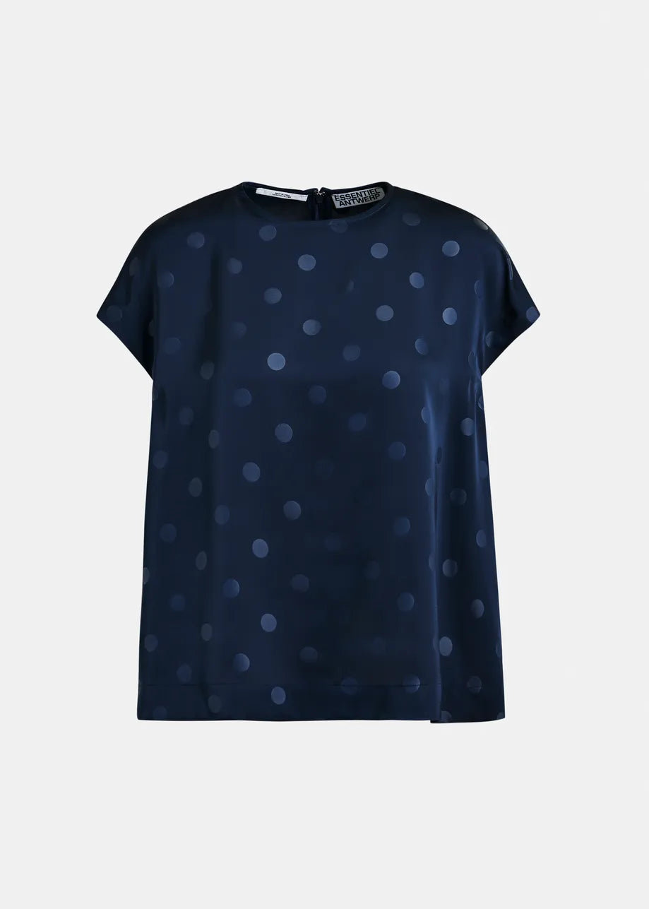 Navy blue blouse with white polka dots on a light gray background