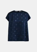 Navy blue blouse with white polka dots on a light gray background