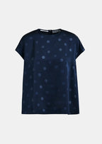 Navy blue blouse with white polka dots on a light gray background