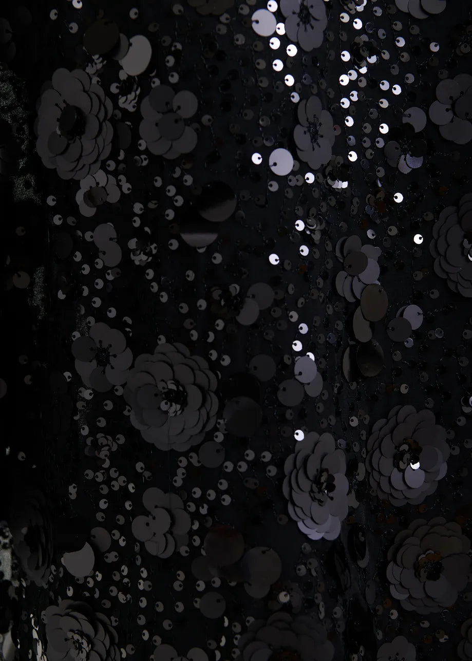 Black floral pattern with silver sequins on a dark background