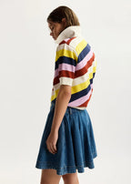 Person wearing a colorful striped sweater and denim skirt on a white background