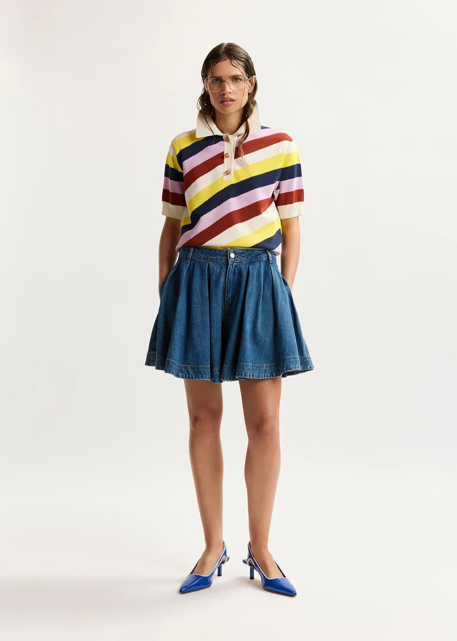 Woman wearing a colorful striped shirt and denim skirt on a white background