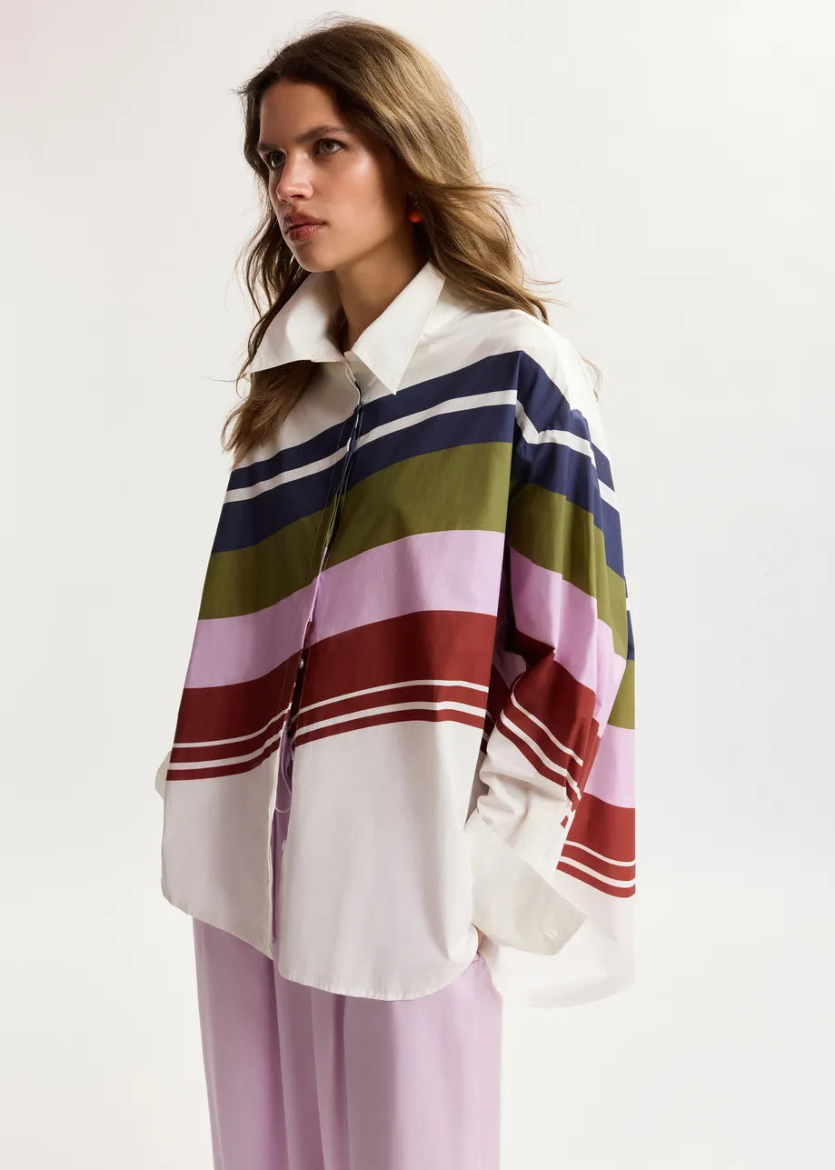 Woman wearing a colorful striped shawl over a white shirt on a white background