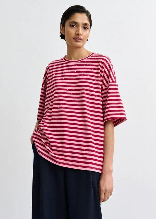 Woman wearing a red and white striped shirt with a plain background