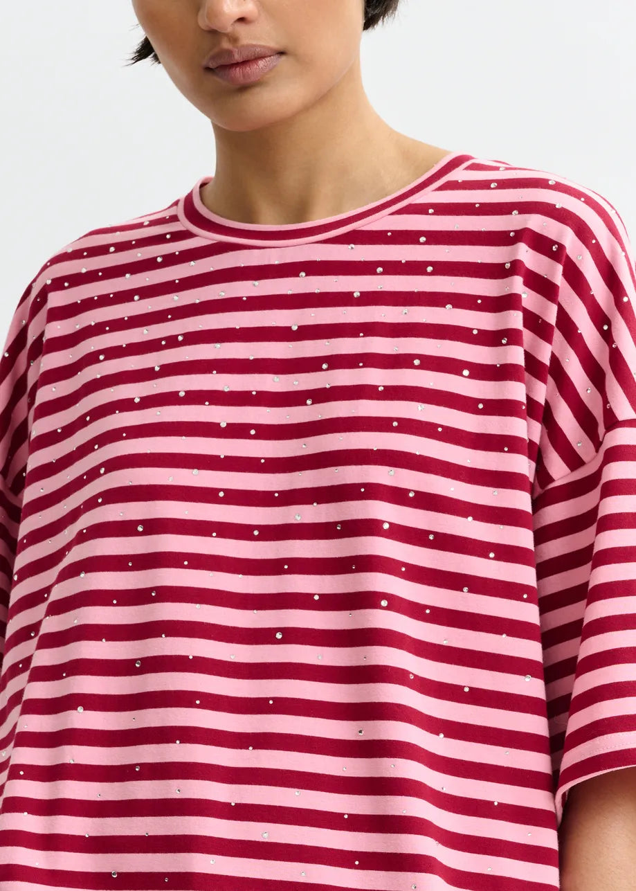 Person wearing a red and white striped shirt with small dots on a plain background