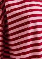 Close-up of red and pink striped fabric with small white dots.