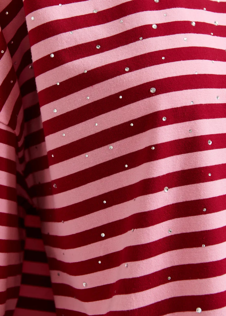 Close-up of red and pink striped fabric with small white dots.
