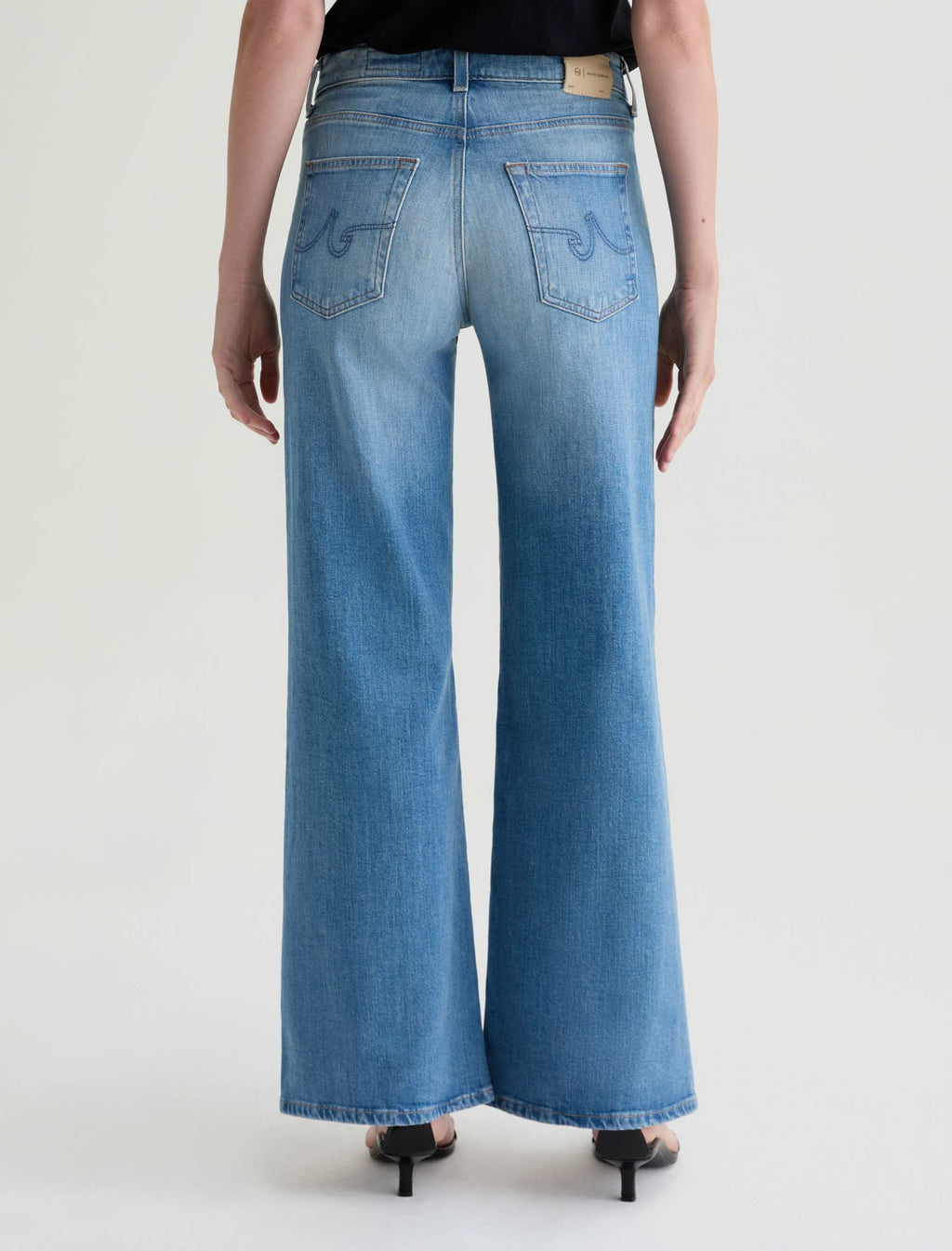 Person wearing blue wide-leg jeans on a white background