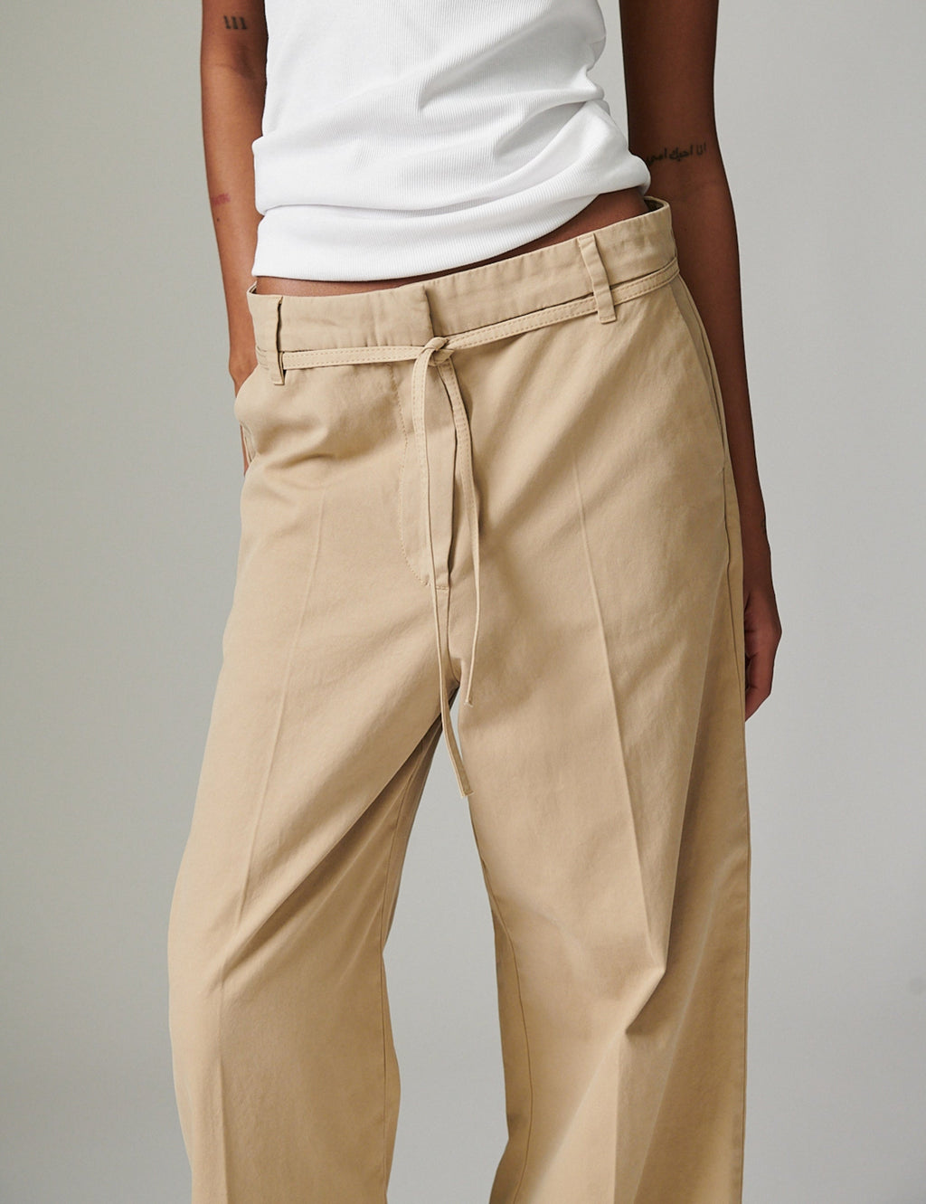 Beige pants worn by a person on a plain background