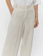 Beige pants worn by a person on a white background