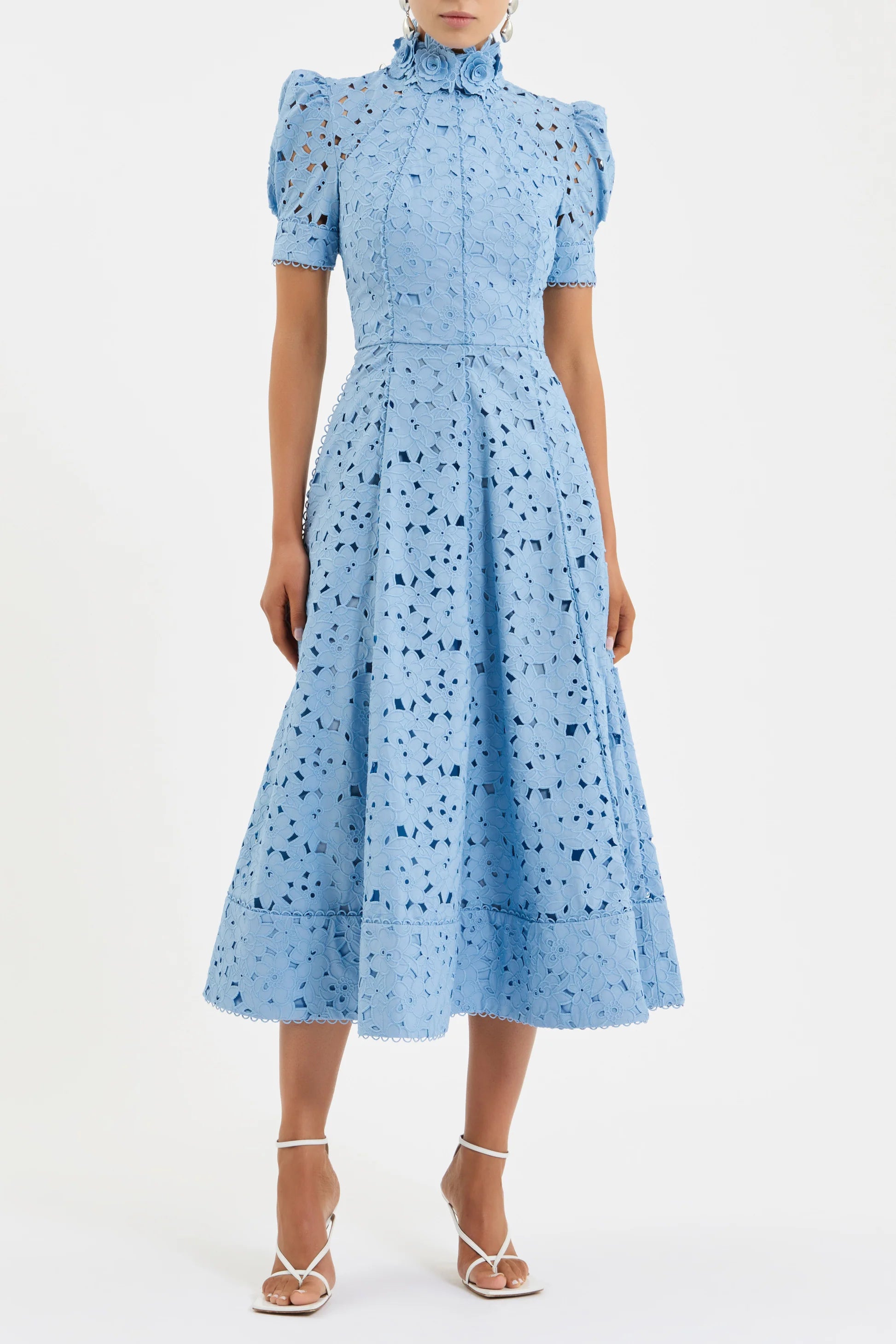 Woman wearing a light blue dress with a pattern on a white background