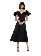 A woman wearing an off-shoulder midi dress with frill sleeves and a wide V neckline. The dress is black with an A-line silhouette.