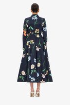 Navy dress with colorful floral pattern worn by a model on a white background