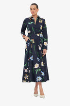 Woman wearing a navy dress with floral pattern on a white background