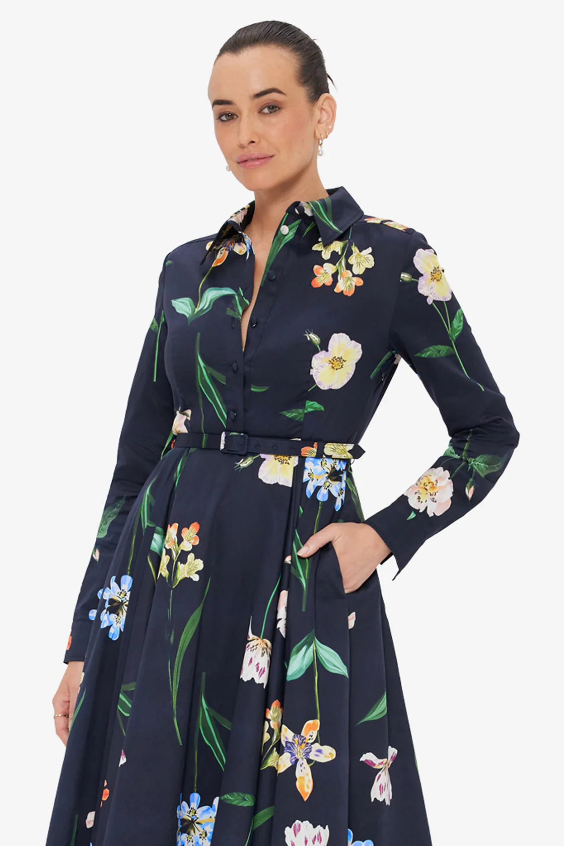 Woman wearing a navy floral dress against a white background