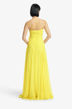 Woman wearing a yellow dress with thin straps on a white background