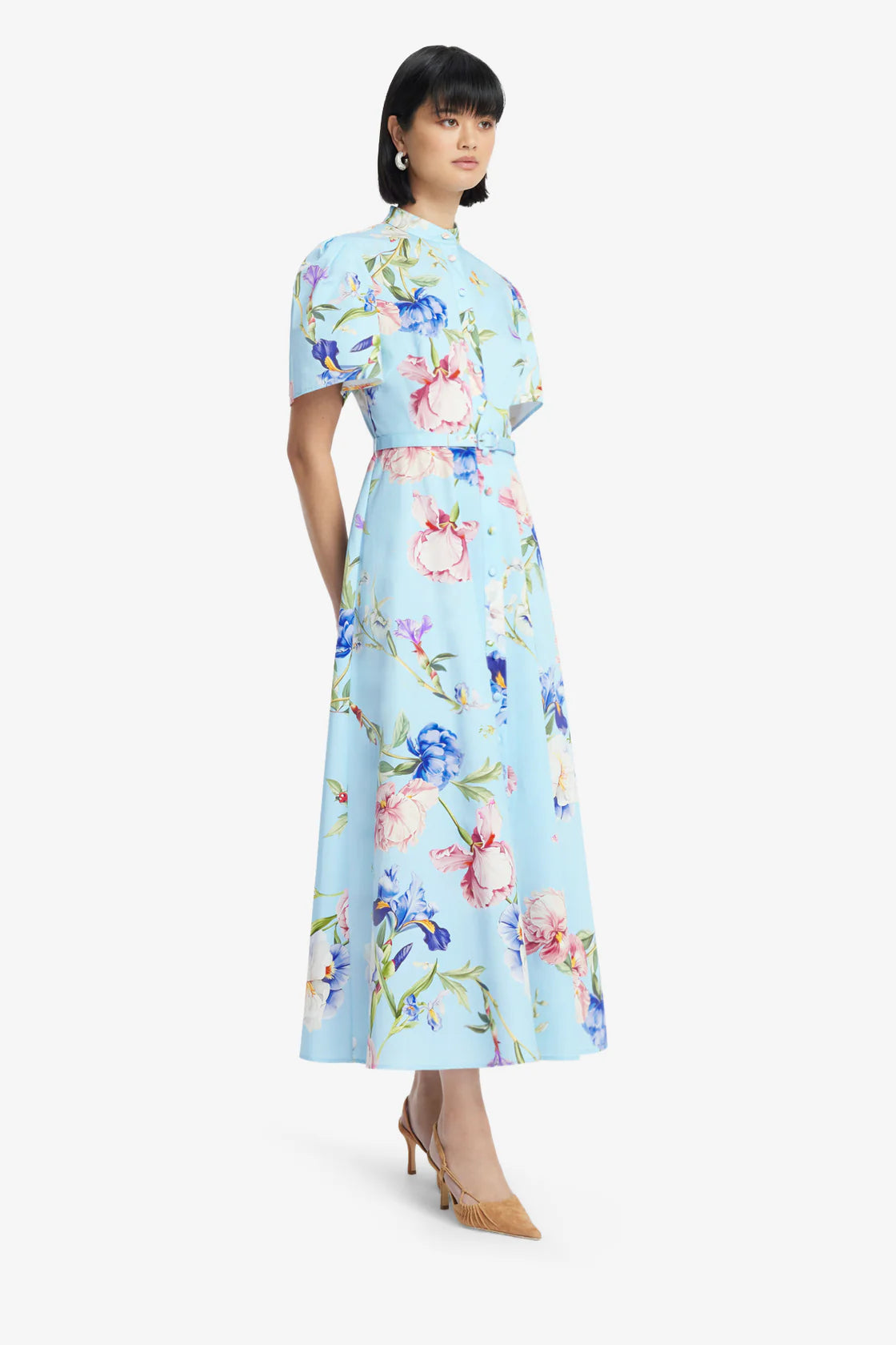 Woman wearing a light blue floral dress on a white background