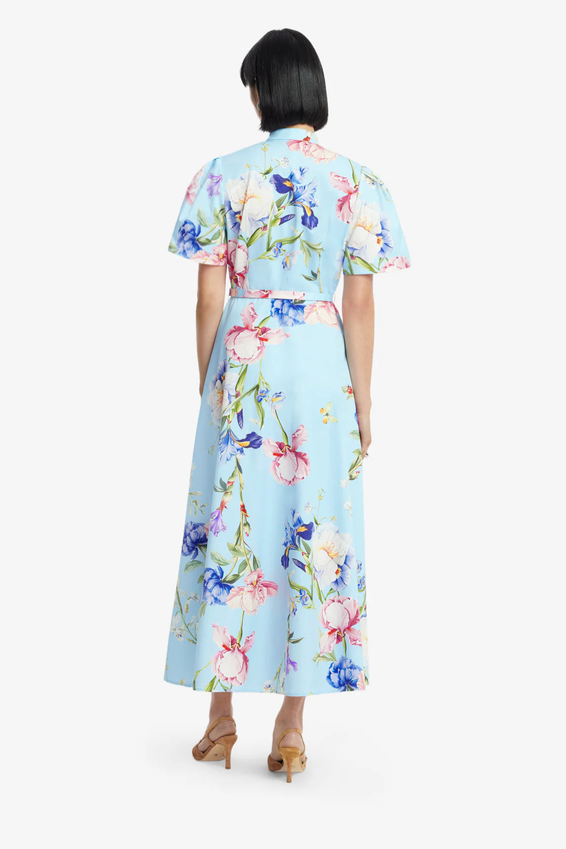 Woman wearing a light blue floral dress on a white background