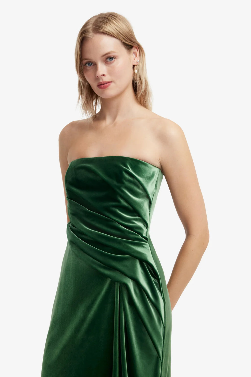 Woman wearing a strapless green dress on a white background