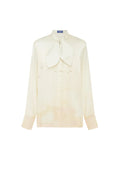A cream-colored long-sleeve button-up shirt with a large bow tie collar and subtle embroidered bird motifs, displayed on a clean white background.