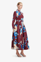 Woman wearing a burgundy dress with floral pattern on a white background