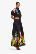 Woman wearing a black outfit with floral patterns on a white background