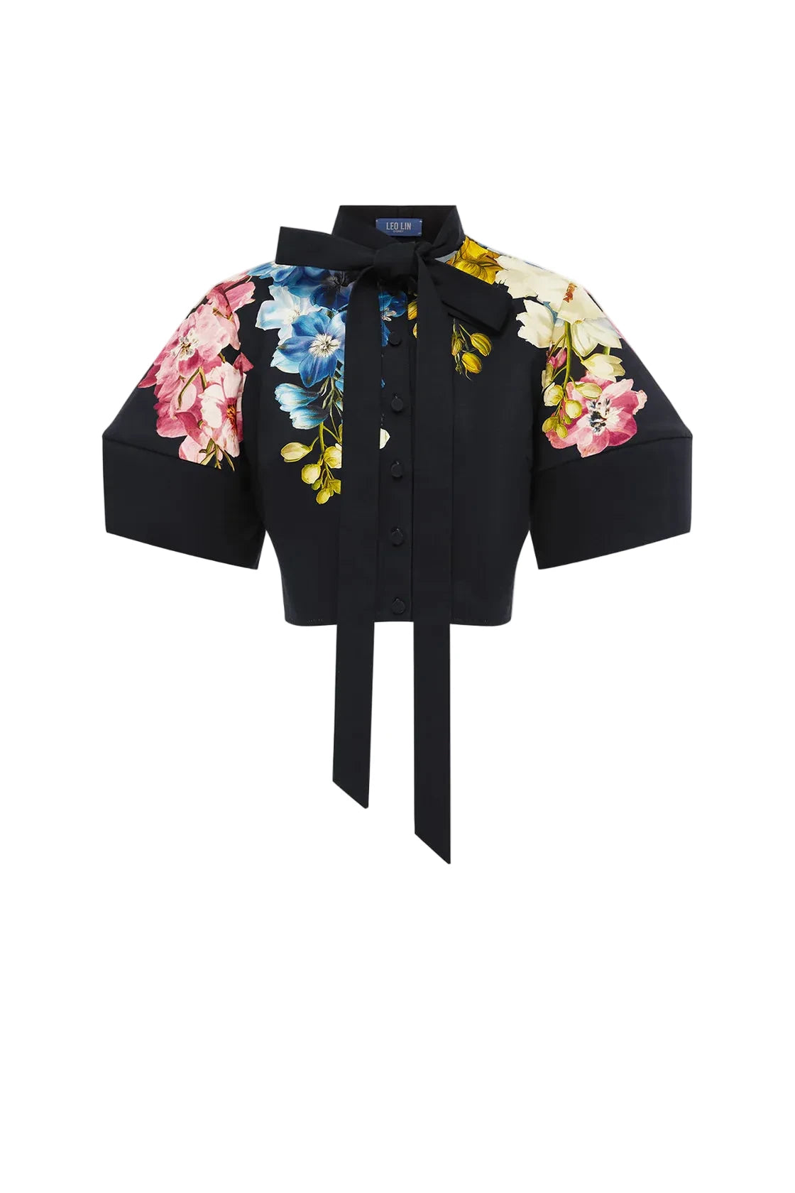 A black short-sleeve button-front blouse with a large bow at the collar, a tie waist, and colorful floral prints on the chest and both sleeves, shown on a plain light gray background.