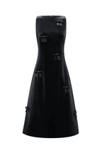 A black strapless midi dress with structured, boxy panel details and tassel-like accents, shown against a plain light gray background.