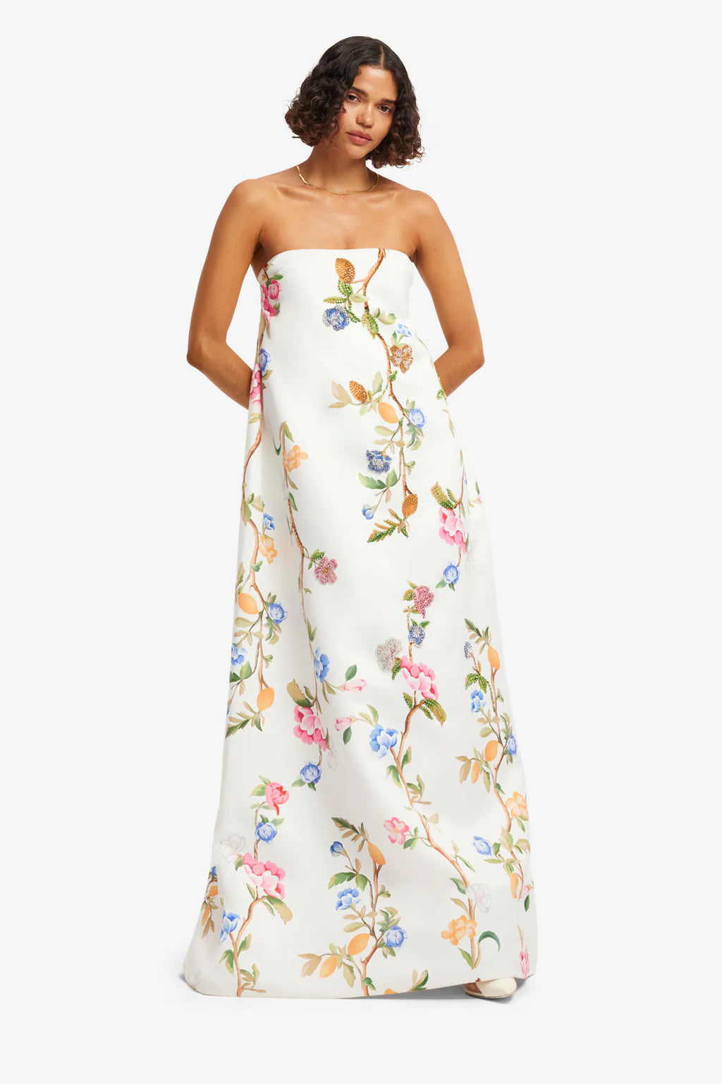 Woman wearing a floral strapless gown on a white background