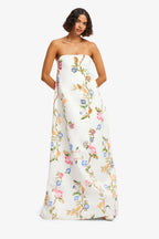 Woman wearing a floral strapless gown on a white background