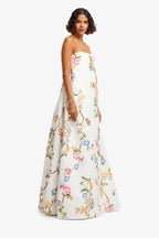 Woman wearing a strapless floral gown on a white background