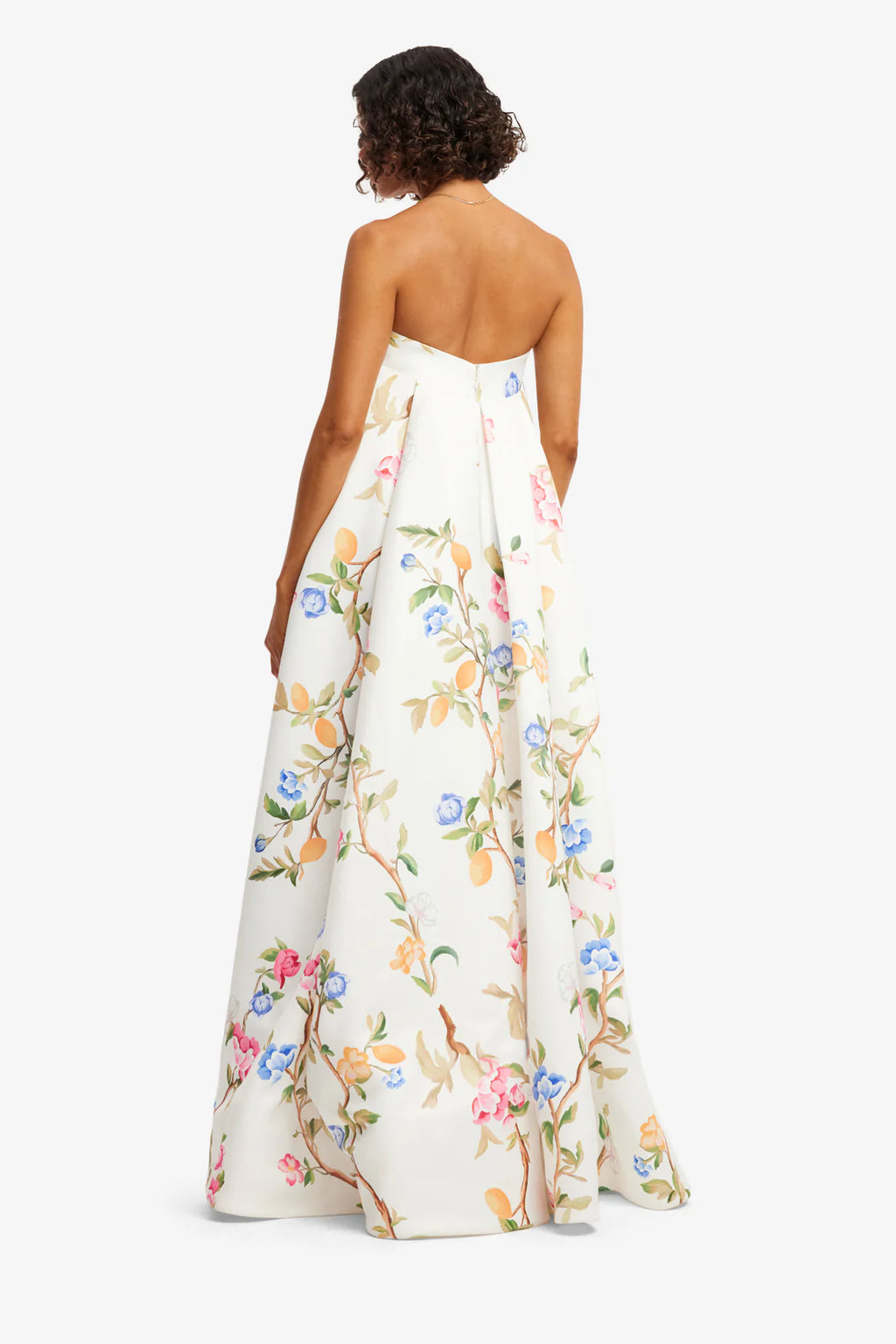 Woman wearing a strapless floral dress on a white background