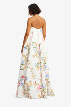 Woman wearing a strapless floral dress on a white background
