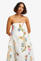 Woman wearing a strapless floral dress against a white background