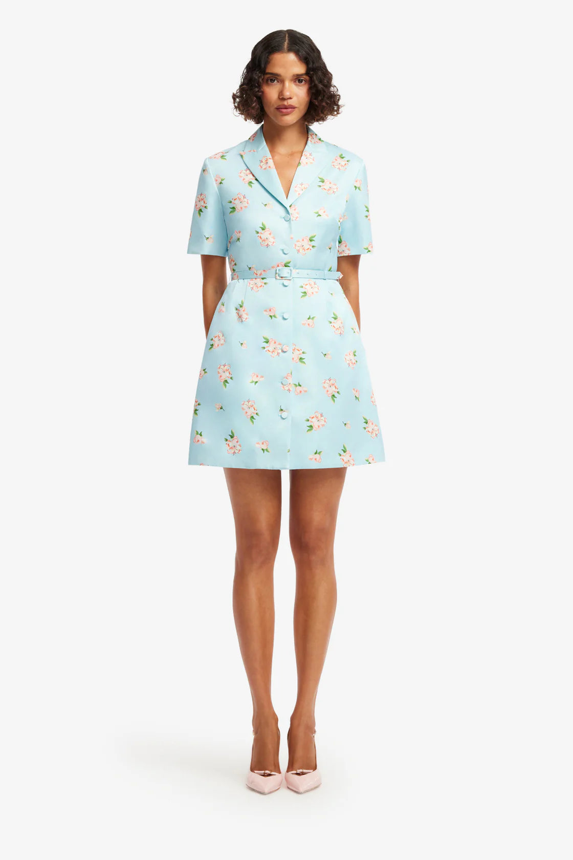 Woman wearing a light blue floral dress on a white background