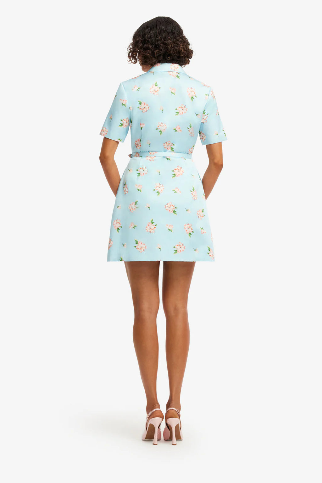 Woman wearing a light blue floral dress on a white background