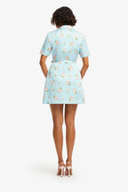 Woman wearing a light blue floral dress on a white background
