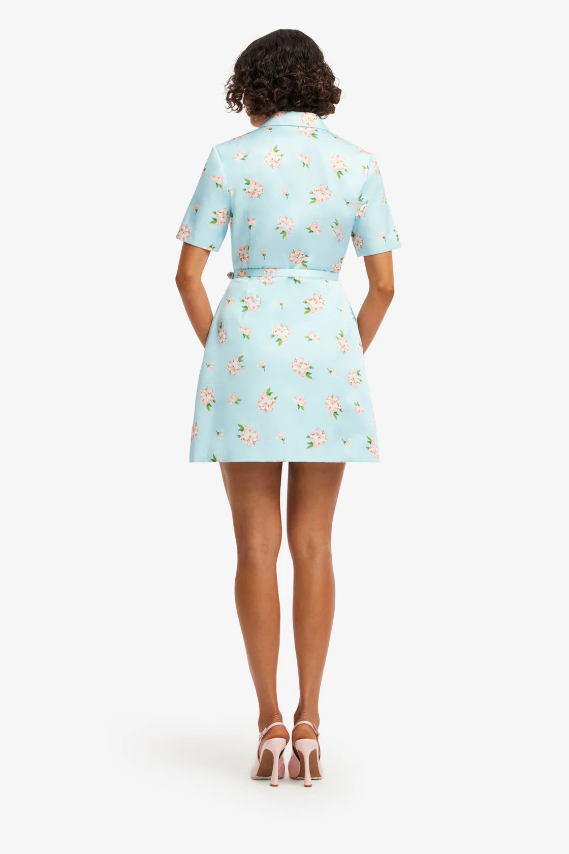 Woman wearing a light blue floral dress on a white background
